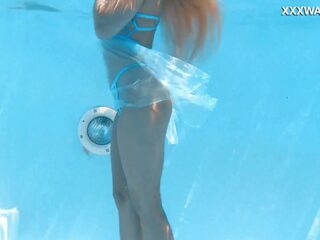 Su cuerpo cutting a través de la shimmering agua de la piscina